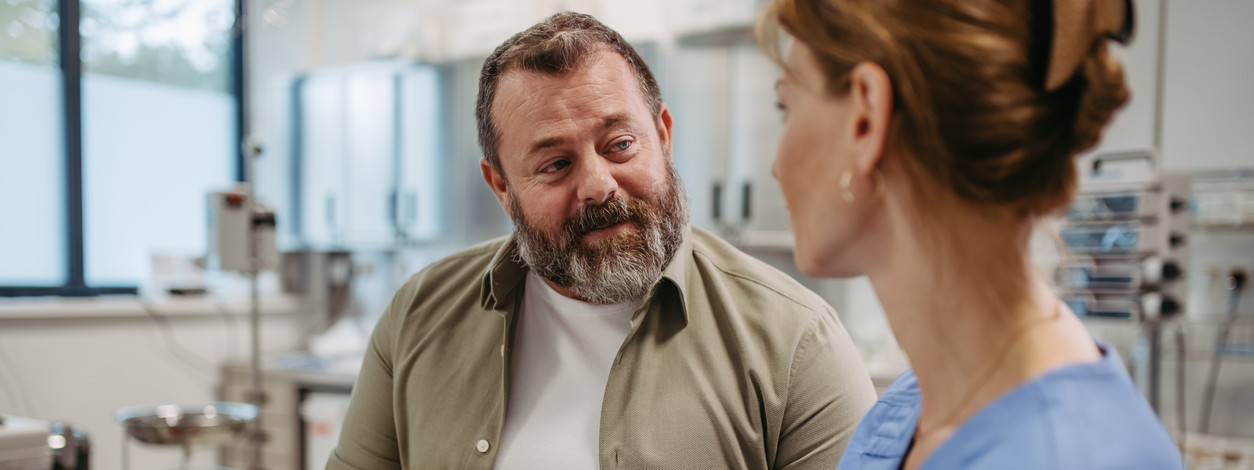 Ärztin berät sich mit übergewichtigen Patienten und bespricht das Testergebnis in der Arztpraxis. 