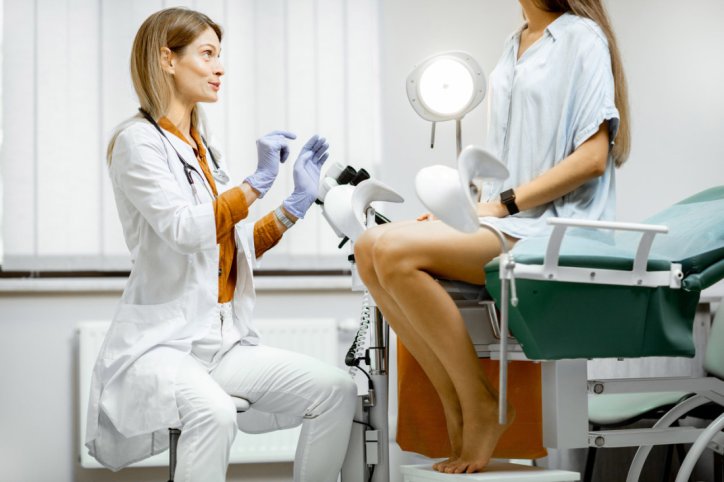 Gynäkologin sitzt vor Frau Patientin und erklärt ihr etwas