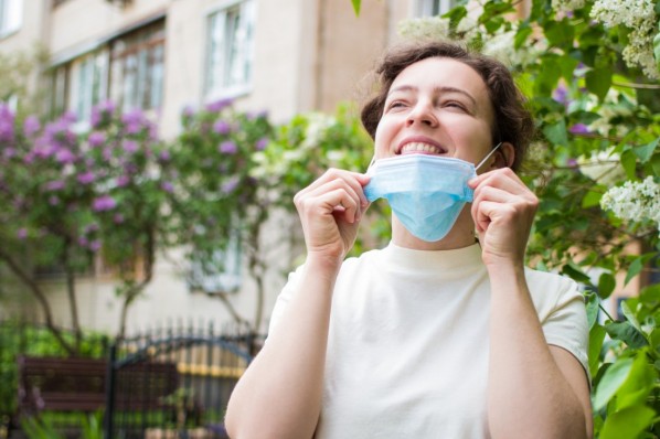 Eine Junge Frau trägt zum Schutz vor Pollen einen Atemschutz