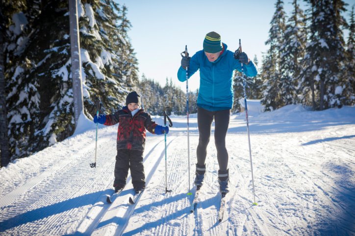 Älterer Mann und sein zirka 5-jähriger Enkel beim Skilanglauf