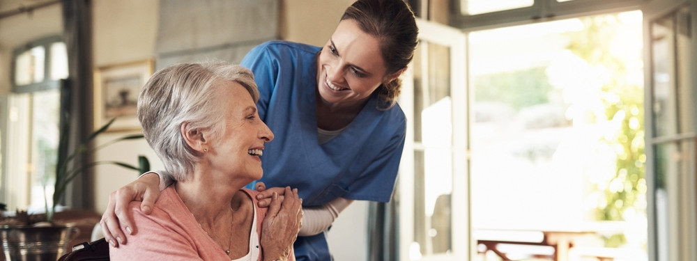 Eine Pflegefachkraft bereut eine Seniorin.