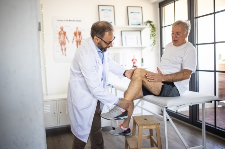 Ein Senior sucht nach einer Sportverletzung einen Arzt auf