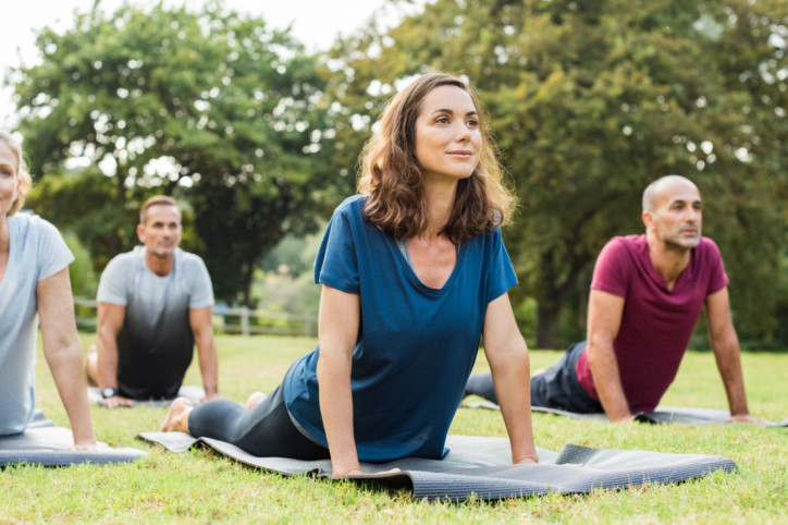 Gruppe aus Frauen und Männern bei Yoga im Park