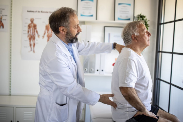 ca. 40-jährige Frau beim Rückentraining mit Gymnastikband
