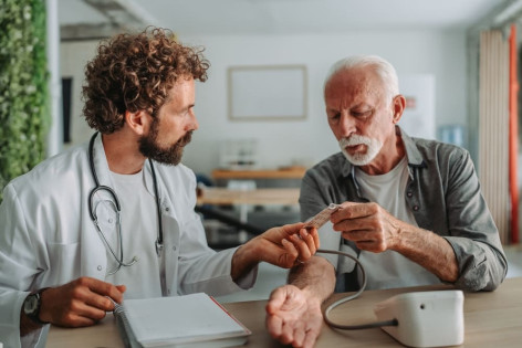 Ein Arzt verschreibt einem älteren Patienten Blutverdünner