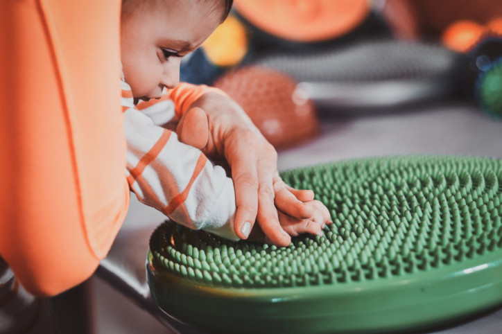 Ein kleiner Junge übt seine Feinmotorik beim Tasten und Fühlen