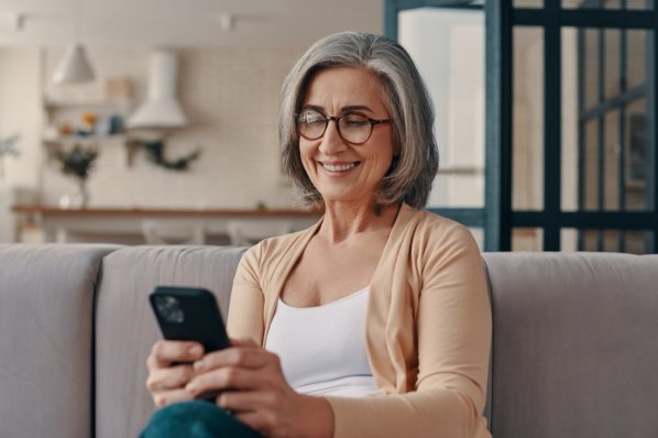 Ältere Frau schaut auf ihr Mobilphone.