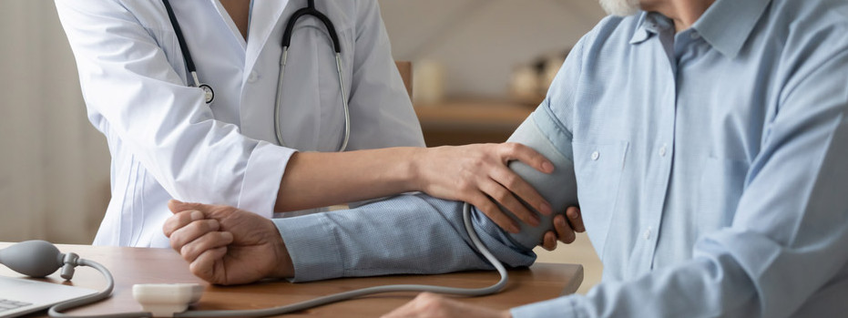 Eine Ärztin untersucht einen Patienten auf Bluthochdruck