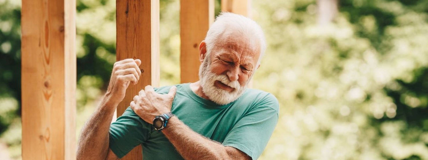 Ein Mann mittleren Alters hält sein Knie besorgt 