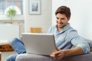 Mann sitzt an einem Laptop