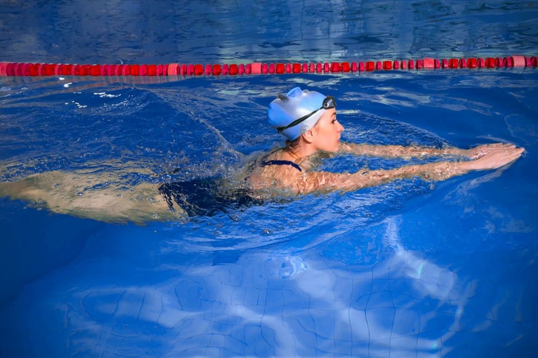Schwimmerin beim Brustschwimmen im Schwimmbad